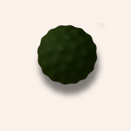 The bobbled dark green ball zoomed in on a pale blush pink background
